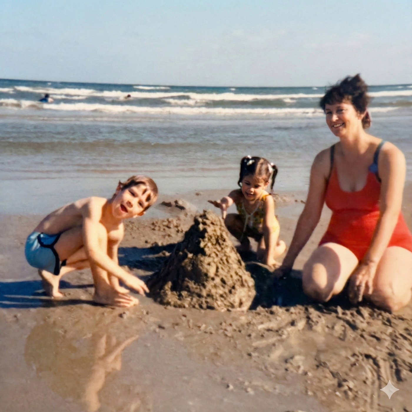 Erik, his sister Julie, and their mom building a sandcastle on the beach